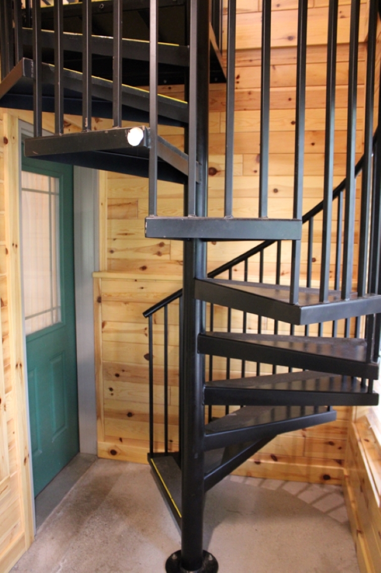 Cabin spiral staircase from main level to walk-out basement level door.