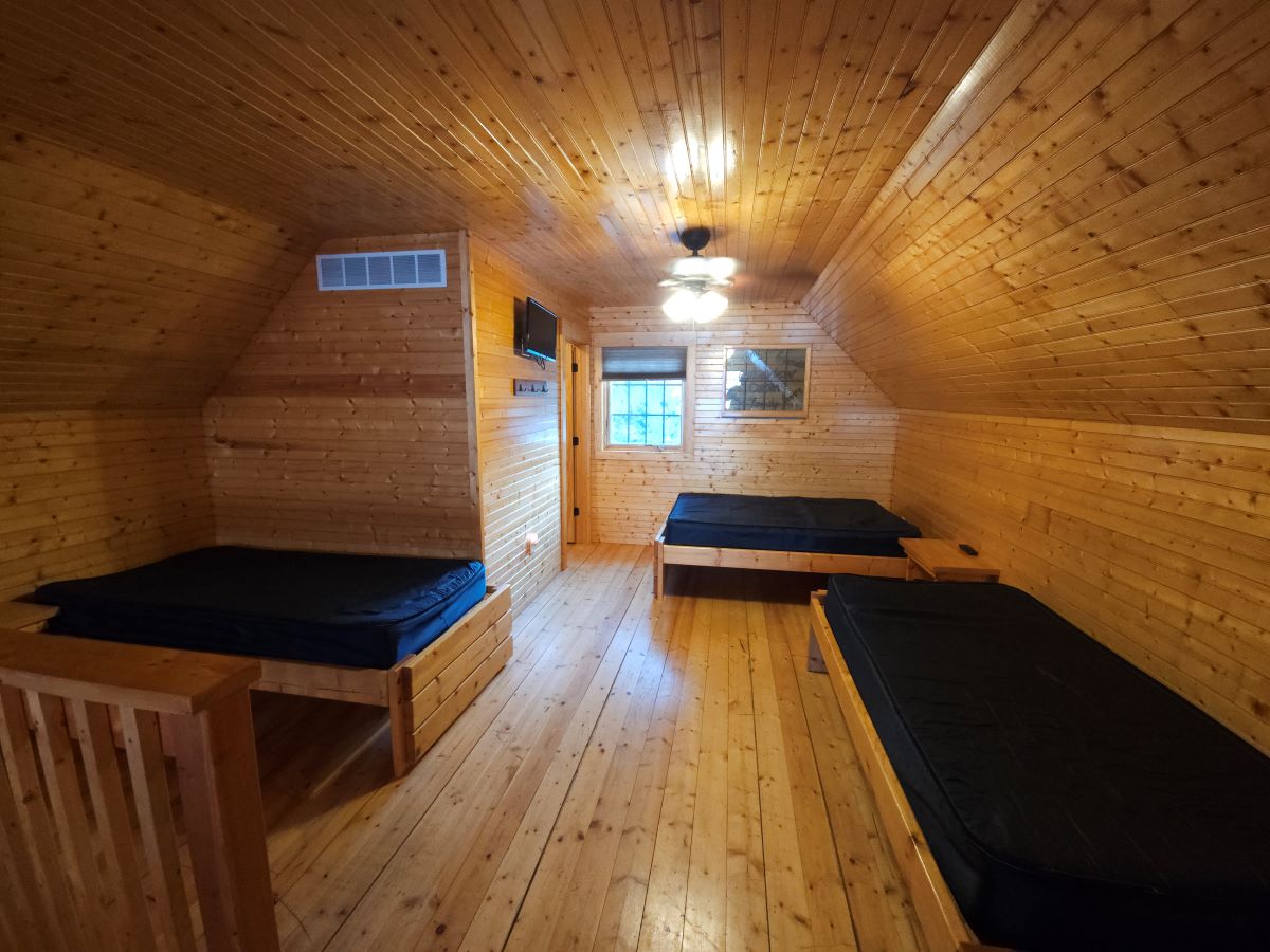 Lakeview cabin upstairs with two twin beds and one full size bed. Bathroom with shower next to the w