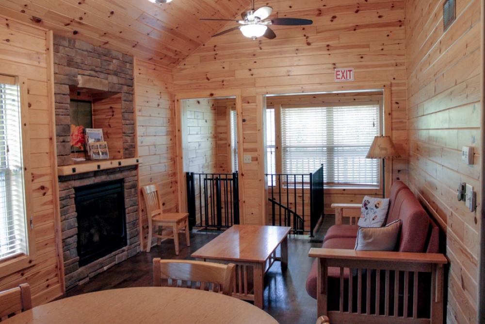 Cabin 4 overview of living room including futon, coffee table, and fireplace