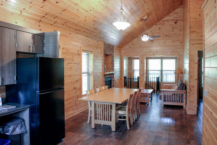 Cabin 3 entrance showing part of the kitchen, as well as the spacious dining table that sits six, an