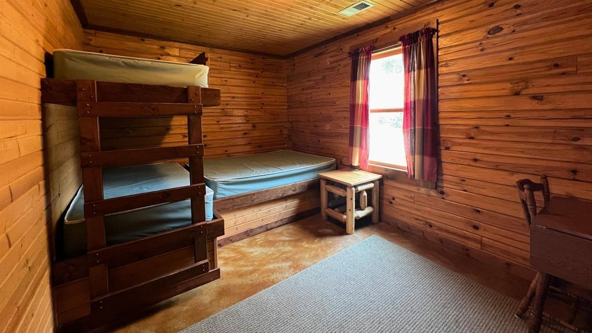 Cabin bedroom with bunk bed and bed