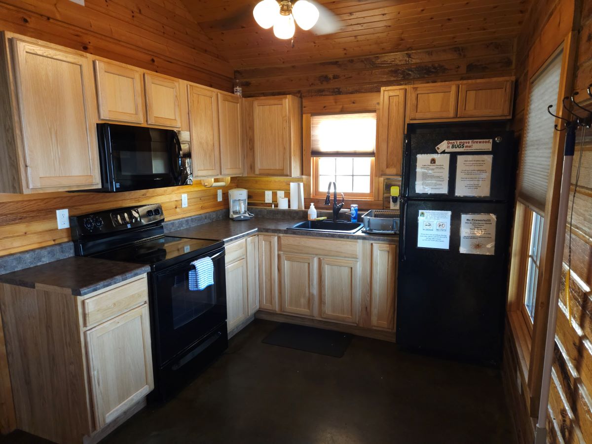 Hilltop Cabin - kitchen area with refrigerator, microwave and stove/oven