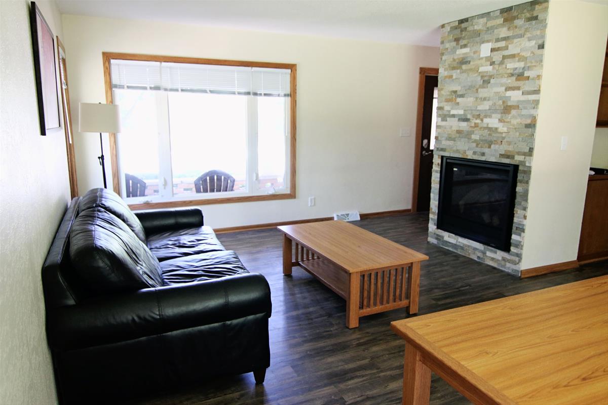 Living room with view of fire place and front porch. Includes eating area, coffee table, and couch